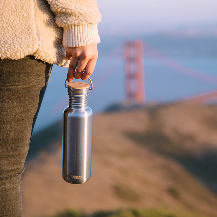 27oz-reflect-with-bamboo-cap-t6 K27SSLRF-BS-BAMBOO_reflect_bottle_bridge_lifestyle.jpg